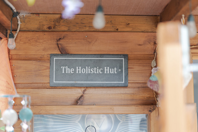 The Holistic Hut sign on wooden wall